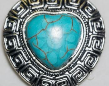 Big natural turquoise stone in a shape of a heart in metal frame.