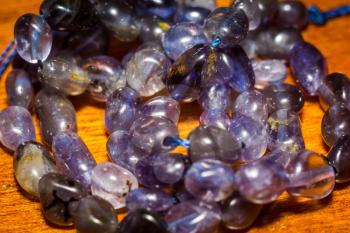 Purple irregular iolite, natural stone beads background.