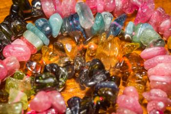 Natural multicolor tourmaline stone, chip beads background.