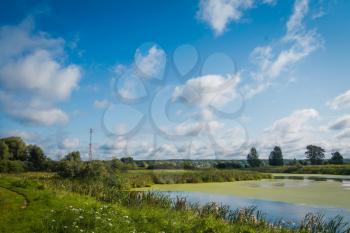 Summer rural landscape with river and blue sky background.