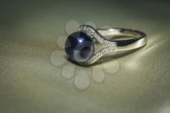 Luxury silver ring with natural freshwater pearl of black color, macro.