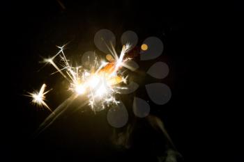Glowing bright party sparkler in the dark background.