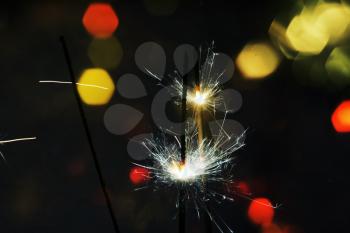 Bengal fire, sparkler and colorful bokeh christmas, new year background.