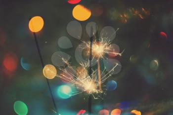 Bengal fire, sparkler and colorful bokeh christmas, new year background.