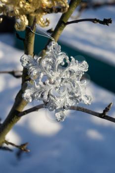 Ornamental silver snowflake glittering on fresh white snow.