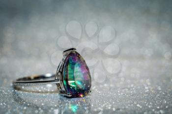 Fashion silver ring decorated with mystic topaz, teardrop shaped stone.