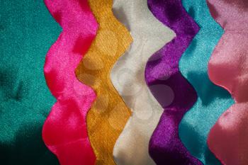 Wavy satin ribbons in different colors abstract background.