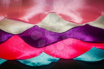 Wavy satin ribbons in different colors abstract background.