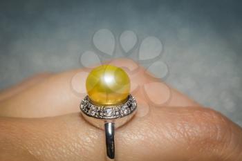 Luxury silver ring with natural freshwater pearl of yellow color, macro.