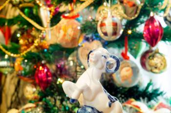 White ceramic ram on background with Christmas decorations.