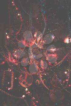 Decorated Christmas tree and colorful garland lights, filtered.