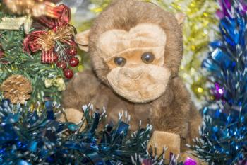 Brown monkey toy with decorated Christmas tree.