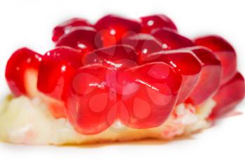 Part of fresh ripe pomegranate with seeds on white background.