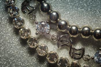 Decorative fashion silver bracelets set on glitter background.