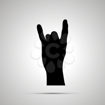 Black silhouette of hand in corna gesture isolated on white