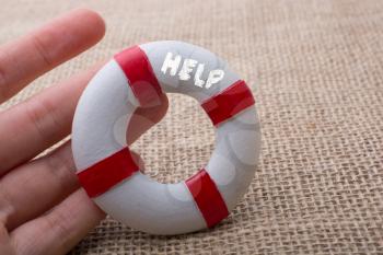 Hand holding a Lifesaver  or life preserver on a fabric background