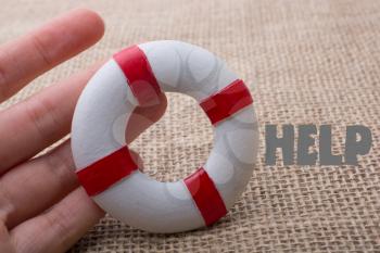Hand holding a Lifesaver  or life preserver on a fabric background