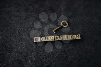 Retro styled decorative key and education wording on dark background