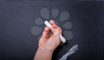 Hand holding  white chalk and black board