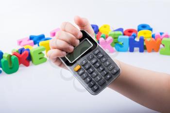 Little calculator in hand with colorful letters behind on white