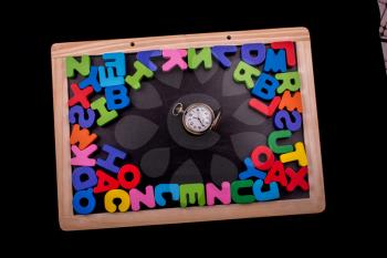 Pocket watch and colorful Letters of Alphabet made of wood