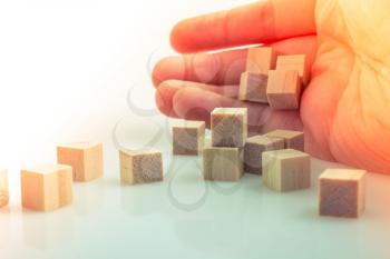 Hand playing with wooden cubes as  educational and business concept