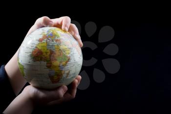 Hand holding a globe  with map on it