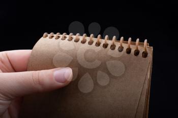 White notebook in hand on  a black color background