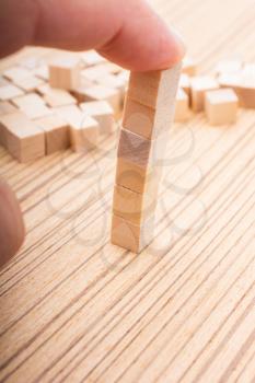 Hand playing with wooden cubes as  educational and business concept