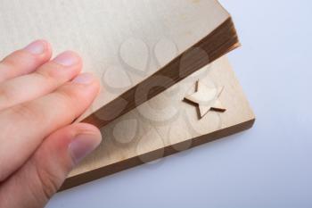 Hand holding a book with a star in its pages