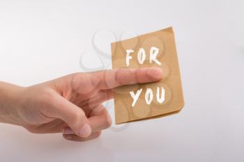 Hand holding paper paper with  For you text