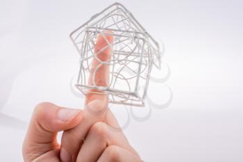 Little  model house made of white metal wire in hand