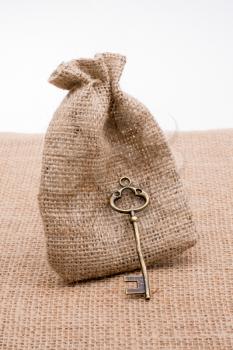 Retro styled golden color key beside a sack