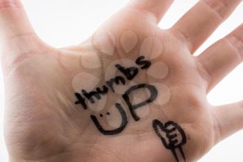 thumbs up written on hand palm on a white background