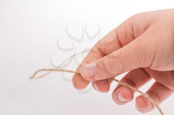 Hand holding  linen thread on a white background