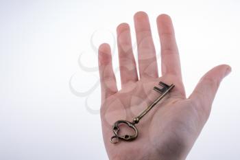 hand holding a  retro styled metal key  on a white background