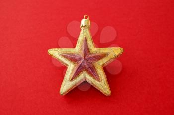 Christmas tree decoration. Golden star on red background.