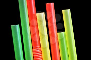 Colorful drinking straws against a black background. Abstract pattern.