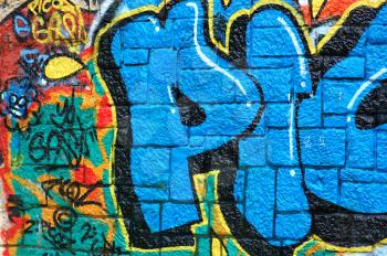 Rough wall surface covered with colorful graffiti. Urban street art background.