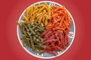 Plate with four flavors of italian fusilli pasta. Food background.