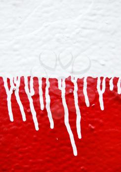 Wall with white dripping paint running over red background. Abstract texture.
