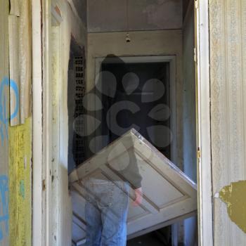 Ghost and unhinged door in the haunted hallway of an abandoned house.