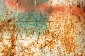 Rusty metal surface with peeled paint and etched numbers. Abstract grunge background.
