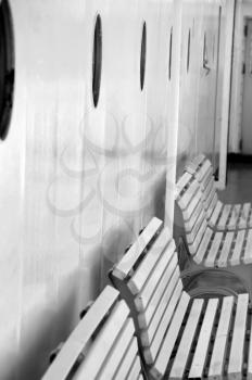 Row of benches on ship deck. Black and white.