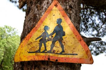 Old rusty traffic control warning sign for school children. Speed restriction.