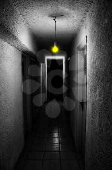 Yellow light glowing in dark underground corridor.