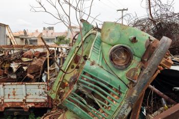Rusty vintage car and scrap metal at a junkyard.