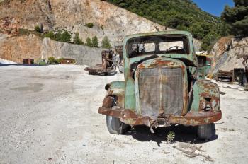 Rusty vintage car and industrial machinery at a quarry.