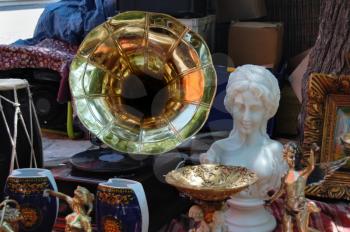 Vintage gramophone vinyl record player and antique objects at street fair.