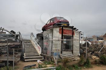 Rusty car and scrap metal at a junkyard.